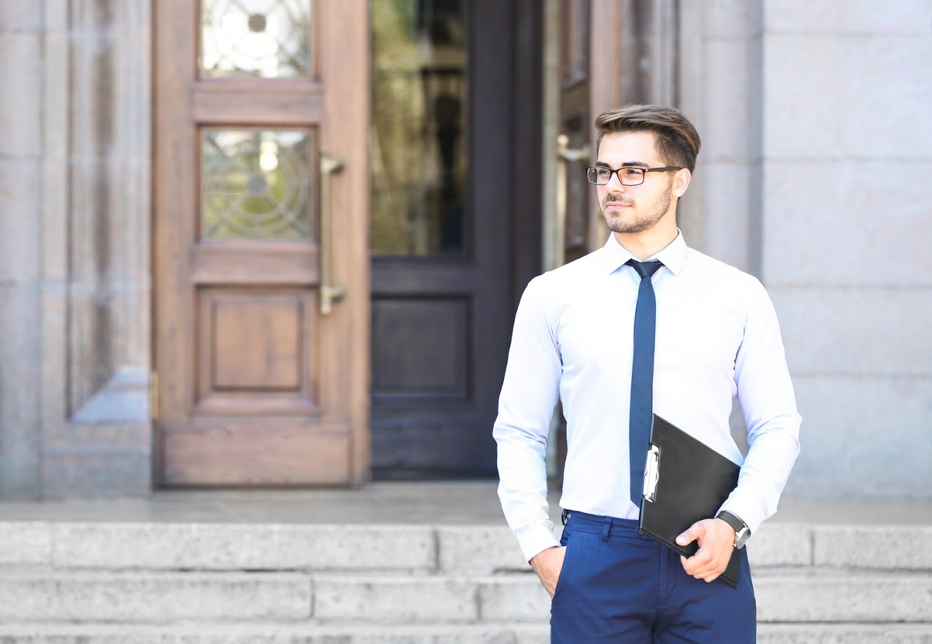Handsome young lawyer with clipboard outdoor