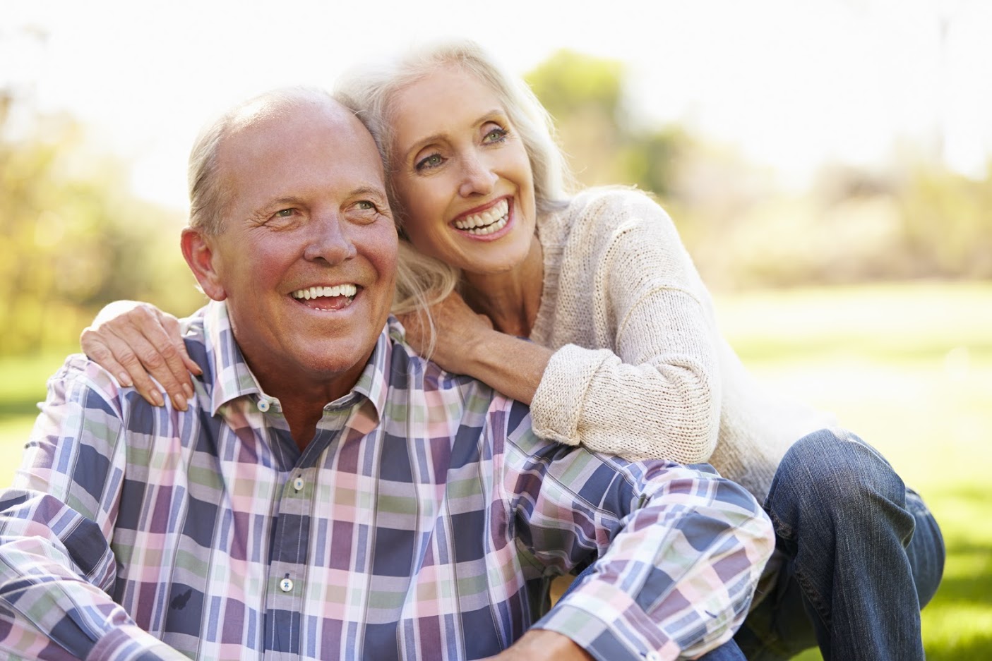 A joyful older couple, smiling and holding hands, exemplifying the positive impact of mental well-being on overcoming erectile dysfunction