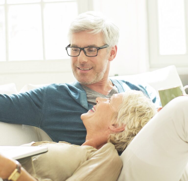 Older couple relaxing together on living room sofa
