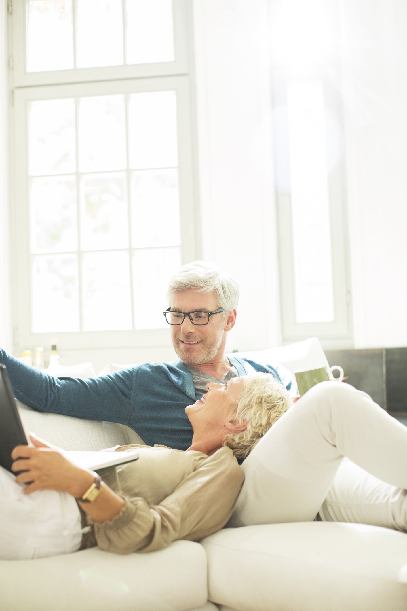 Older couple relaxing together on living room sofa